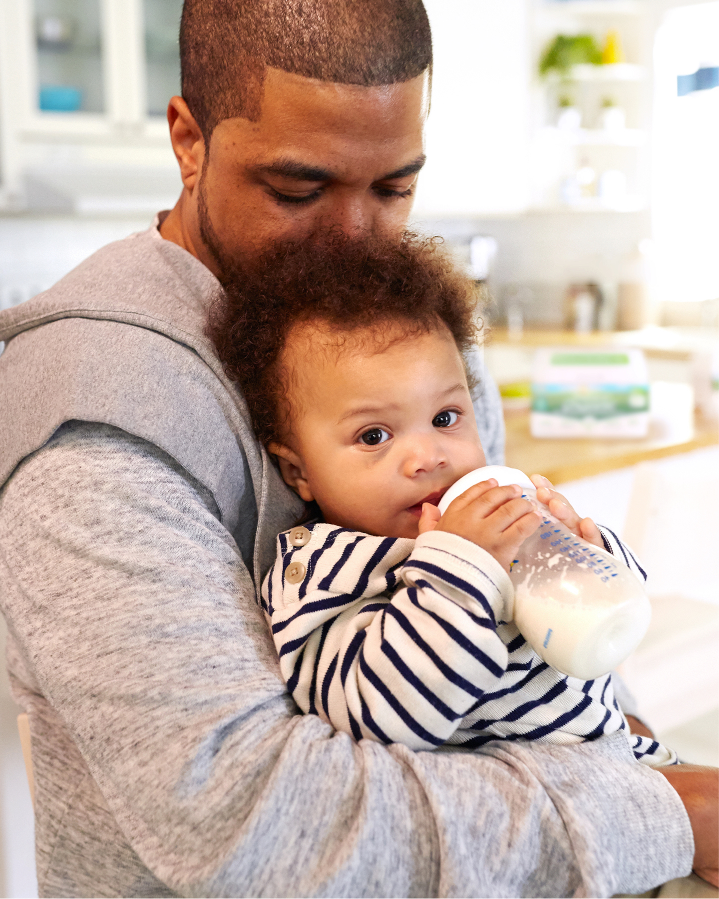 Father holding baby with bottle.