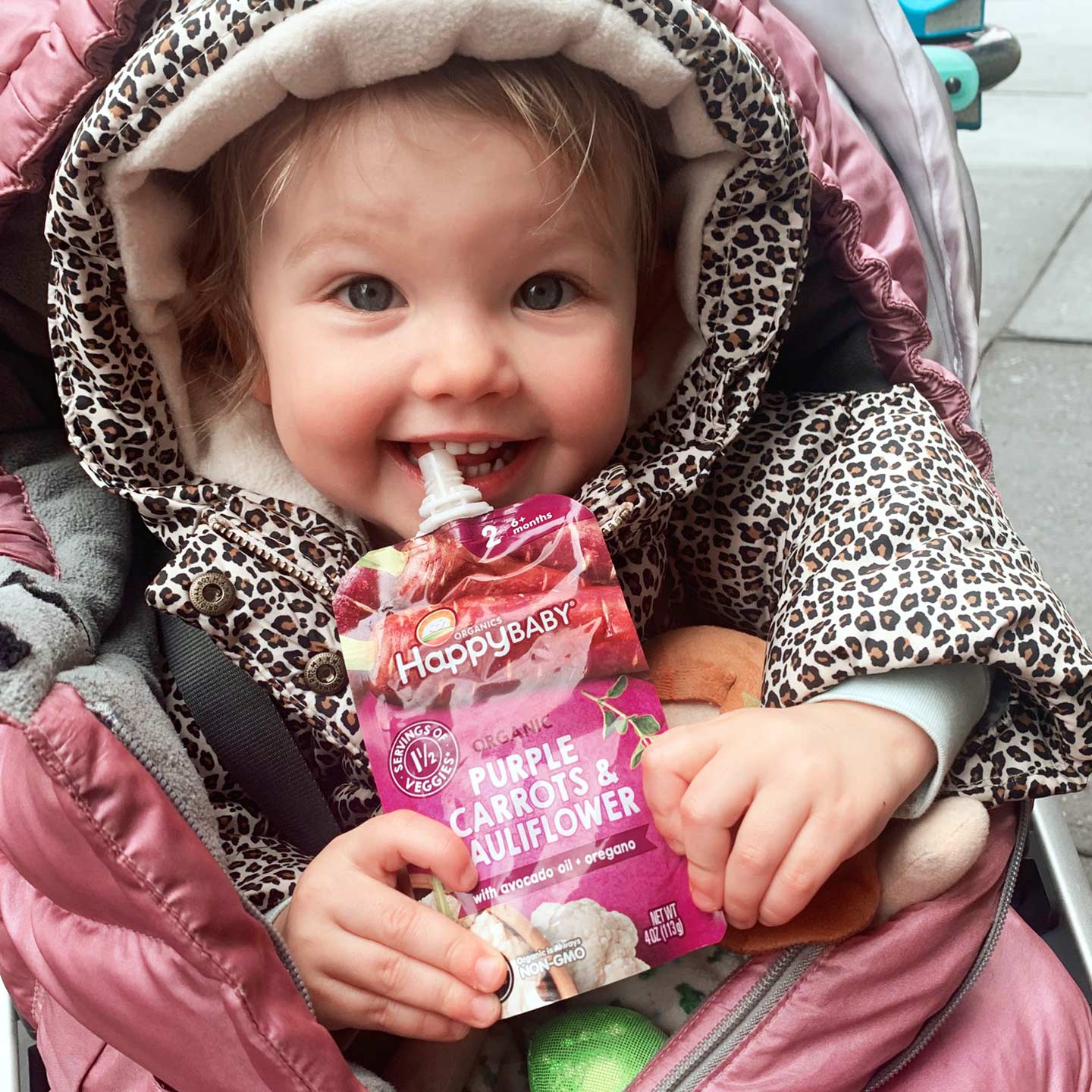 little girl eating Happy Baby Organics Savory Blends Purple Carrots and Cauliflower with avocado oil and oregano baby pouch