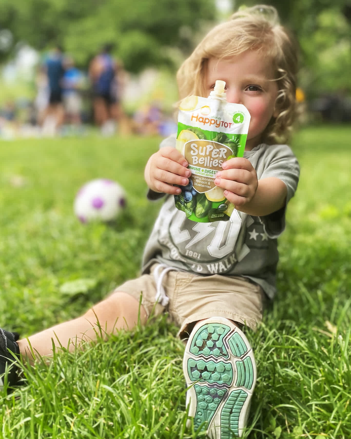 super-bellies-header-of-toddler-sitting-in-grass-holding-up-pouch-lg