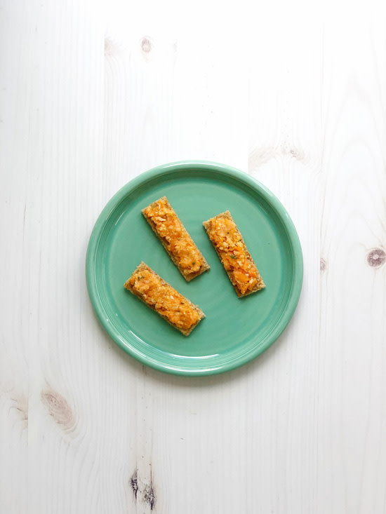 plate of crackers with a carrot and chickpea spread