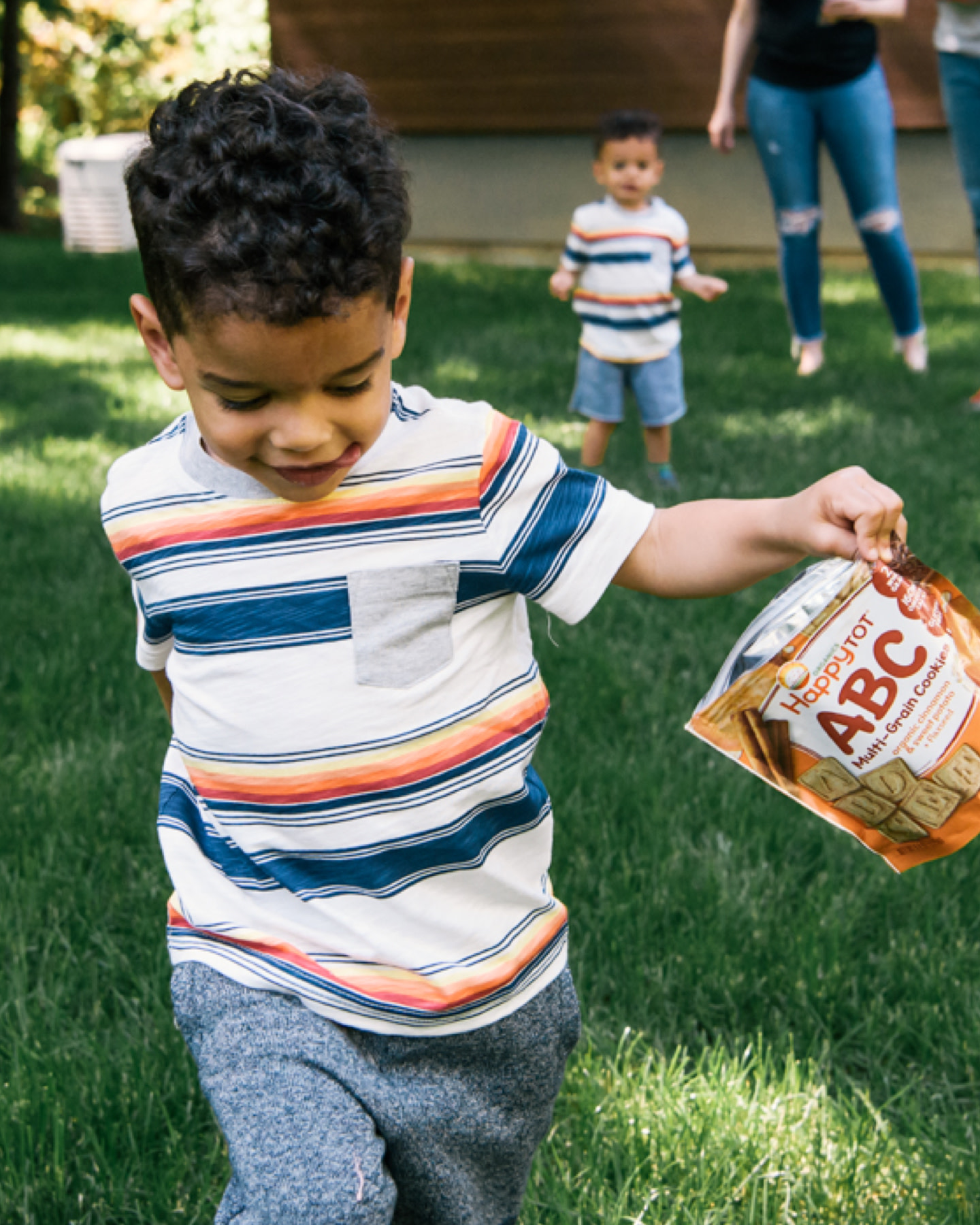 Boy running outside while holding bag of ABC cookies.