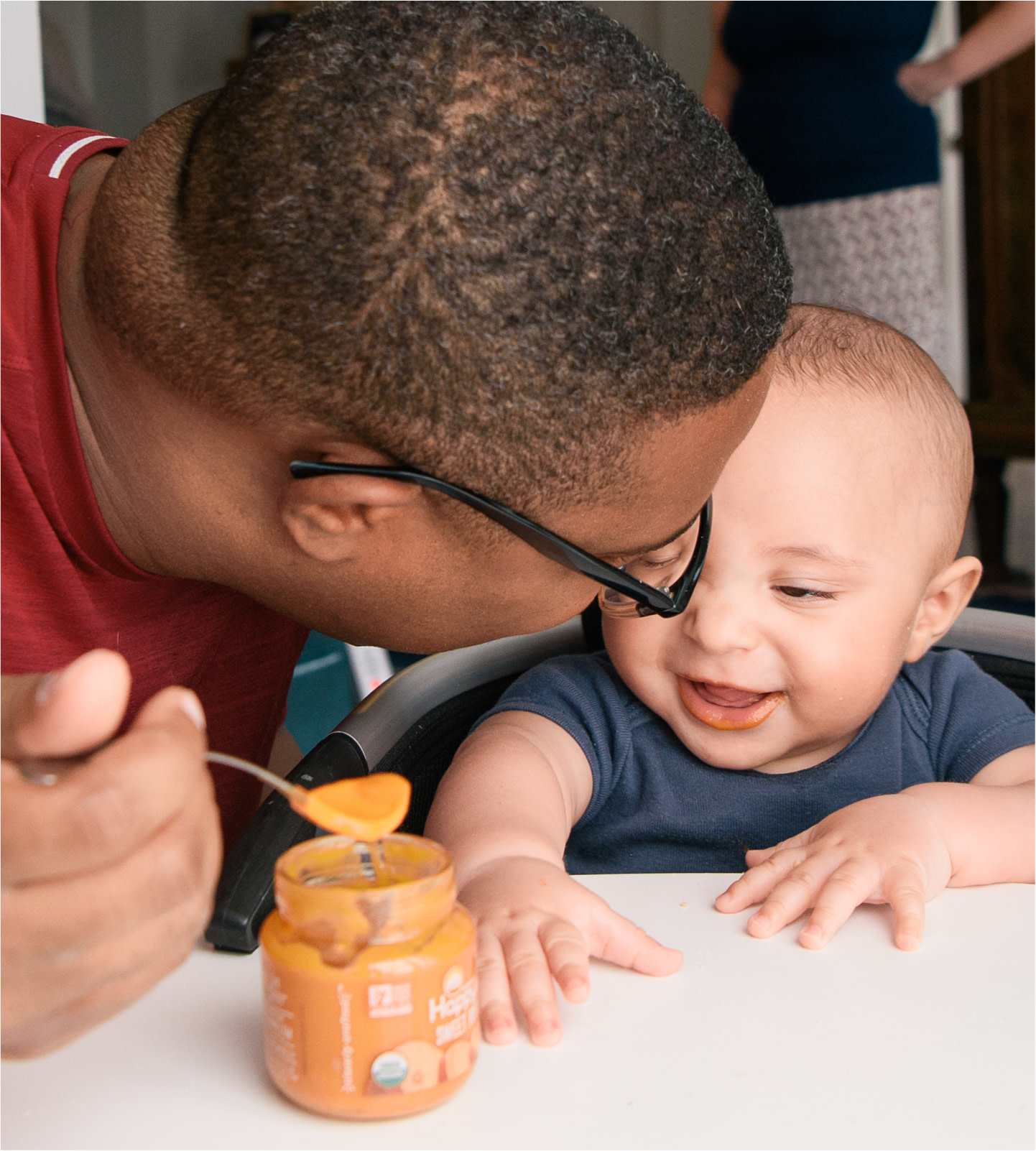 Father spoonfeeding son at table