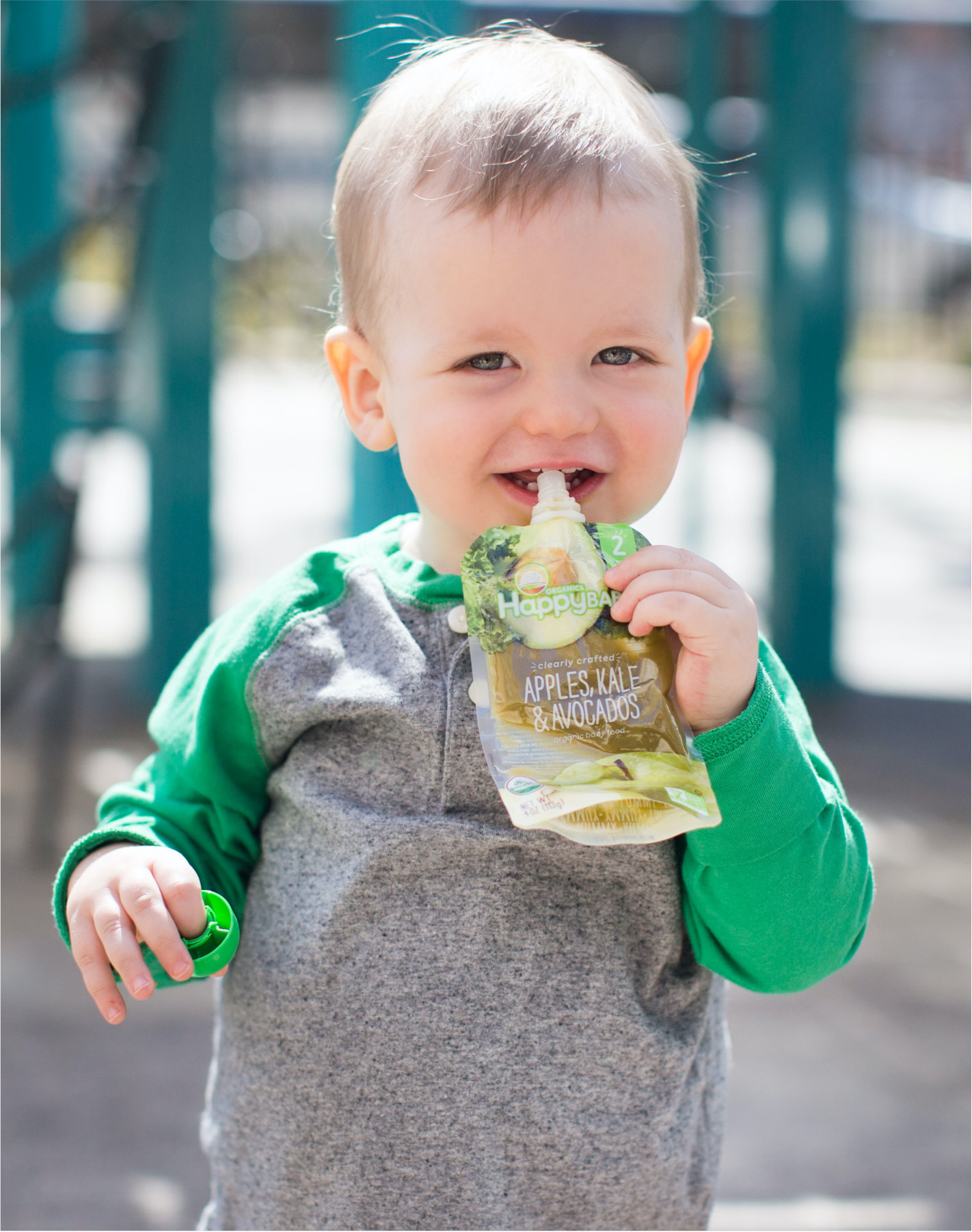 International header of baby eating clearly crafted pouch at playground