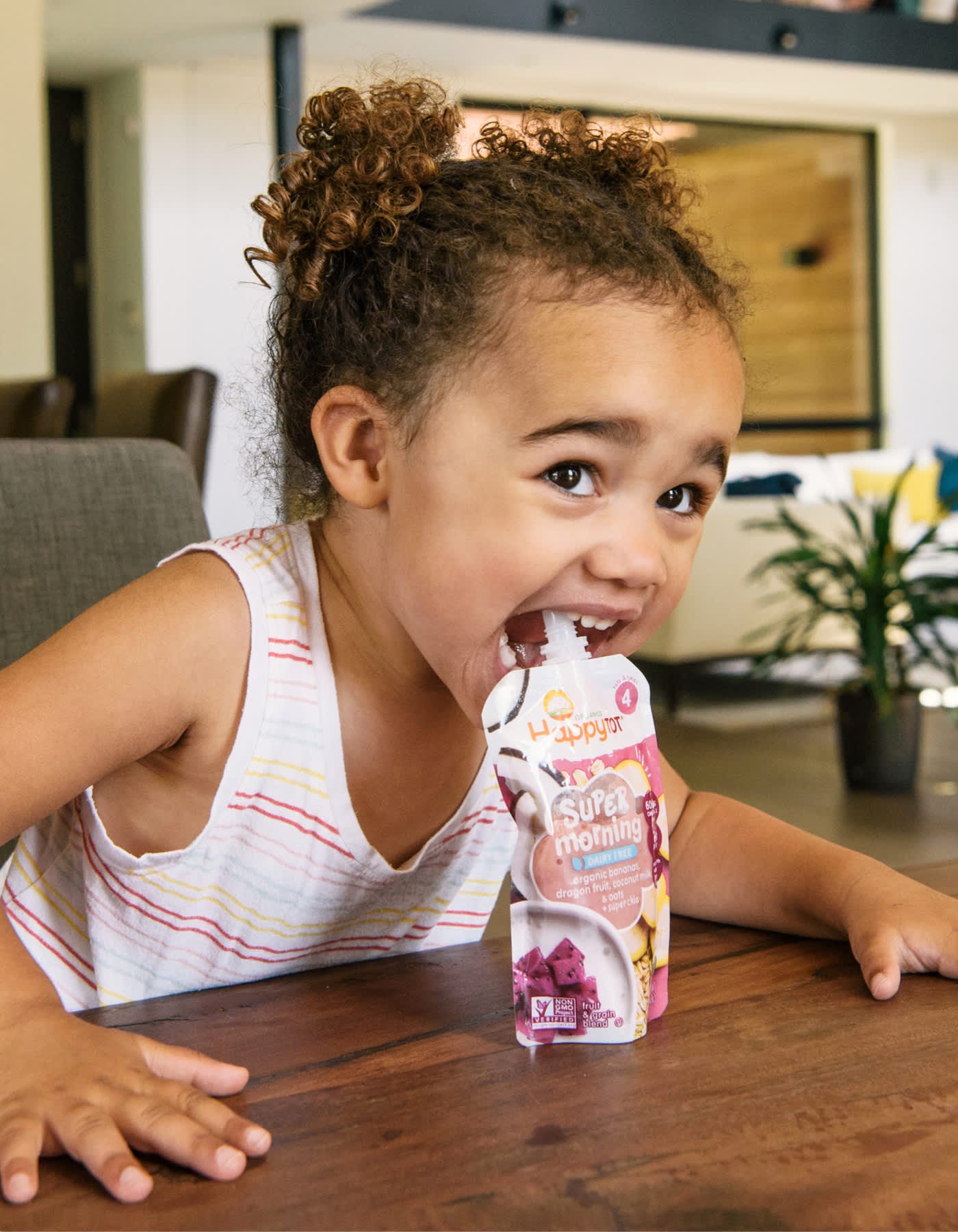 happy-tot-header-of-toddler-leaning-over-pouch-at-dining-table-lg