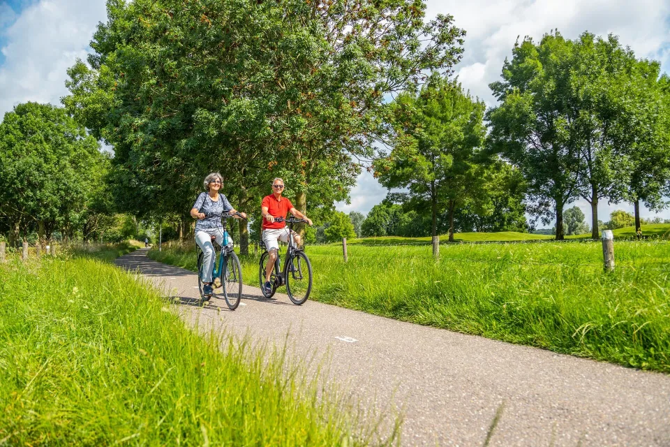 Senioren vakantie stel op fietsvakantie in de natuur in de omgeving van vakantiepark EuroParcs Aan De Maas