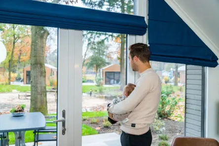 Baby friendly holidays - father with baby in holiday home at holiday park EuroParcs De Hooge Veluwe