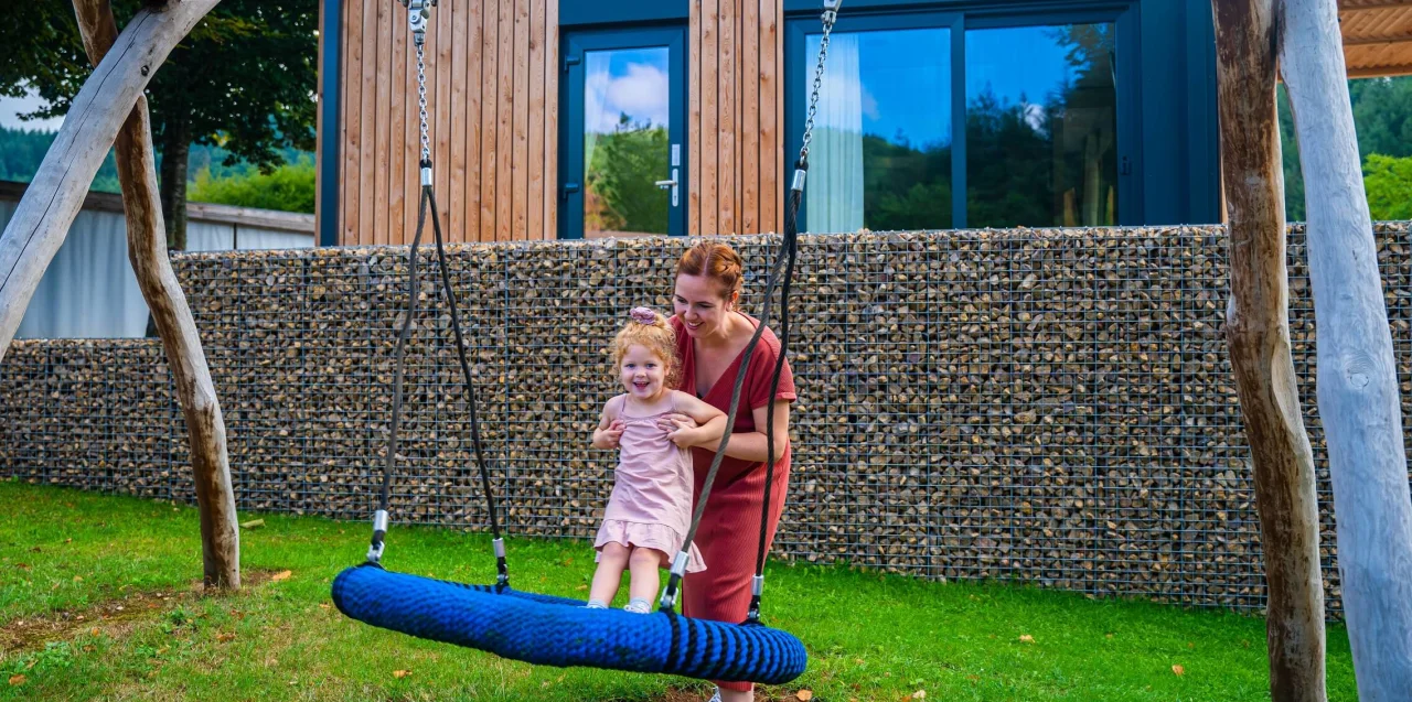 Baby friendly holidays - mother and child on the baby swing at holiday park EuroParcs Kohnenhof