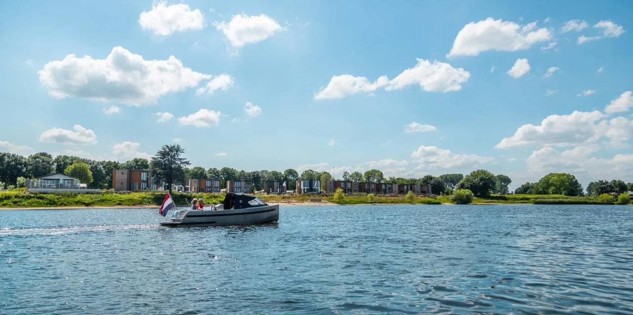 Senior holiday couple rent a boat and sail from holiday home around holiday park EuroParcs Aan De Maas