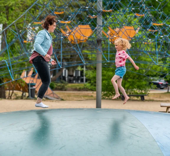 Kind speelt met moeder in speeltuin op vakantiepark EuroParcs De Zanding