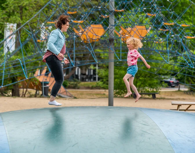 Child playing with mother in playground at holiday park EuroParcs De Zanding