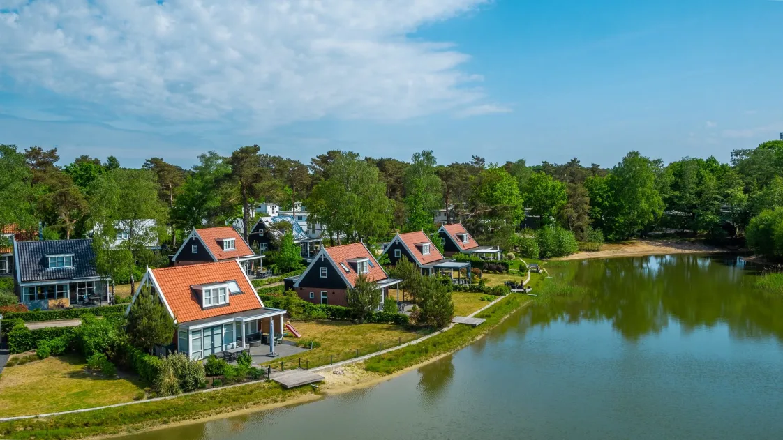 Vakantiepark Veluwe met vakantiehuizen tussen de bomen en het water op EuroParcs De Zanding in Otterlo