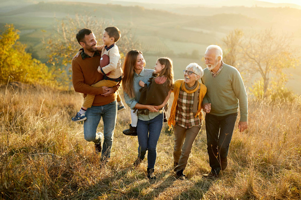 Familie mit drei Generationen auf einem herbstlichen Feld
