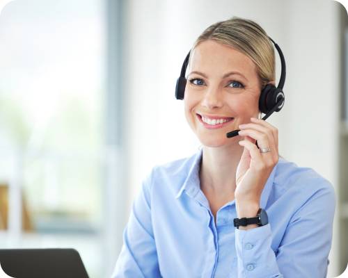 A claims researcher smiles at the camera while adjusting her headset
