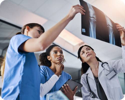 A group of radiologic technologists looks at an x-ray