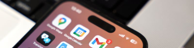 Photograph of a mobile phone showing a wide range of colorful app icons on the home screen