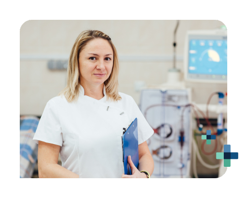 A young female dialysis tech stands in front of the dialysis machine with a clipboard