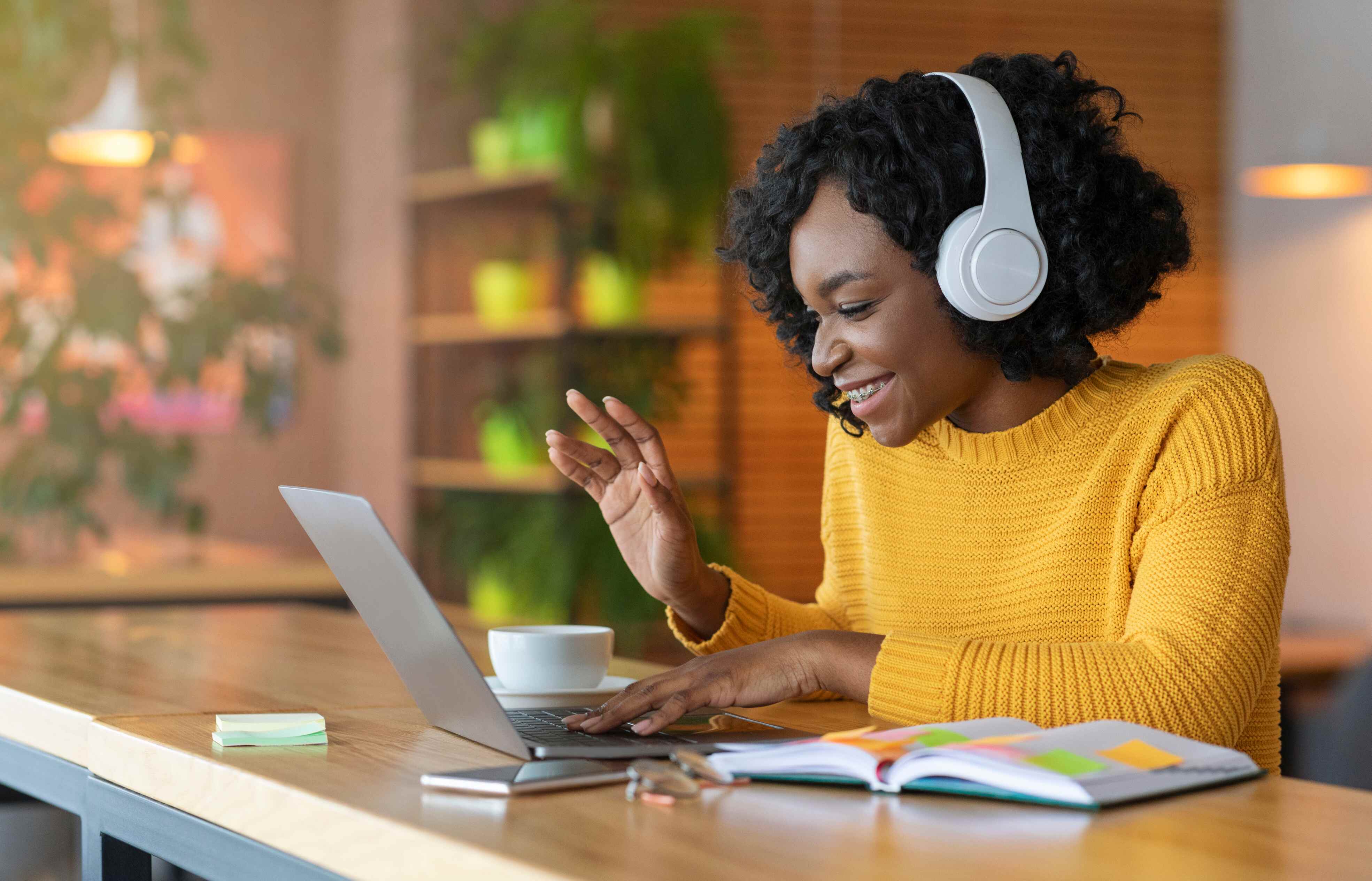 Travel nurse wearing headphones using their laptop in a cafe