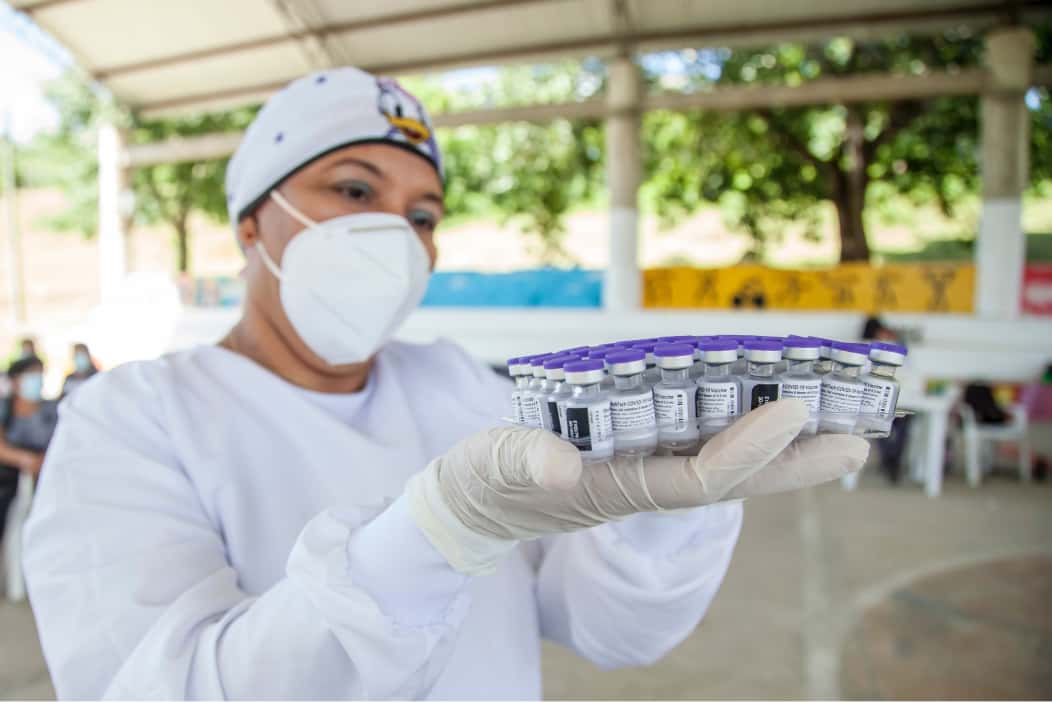 COVID-19 nurse holding vaccine bottles