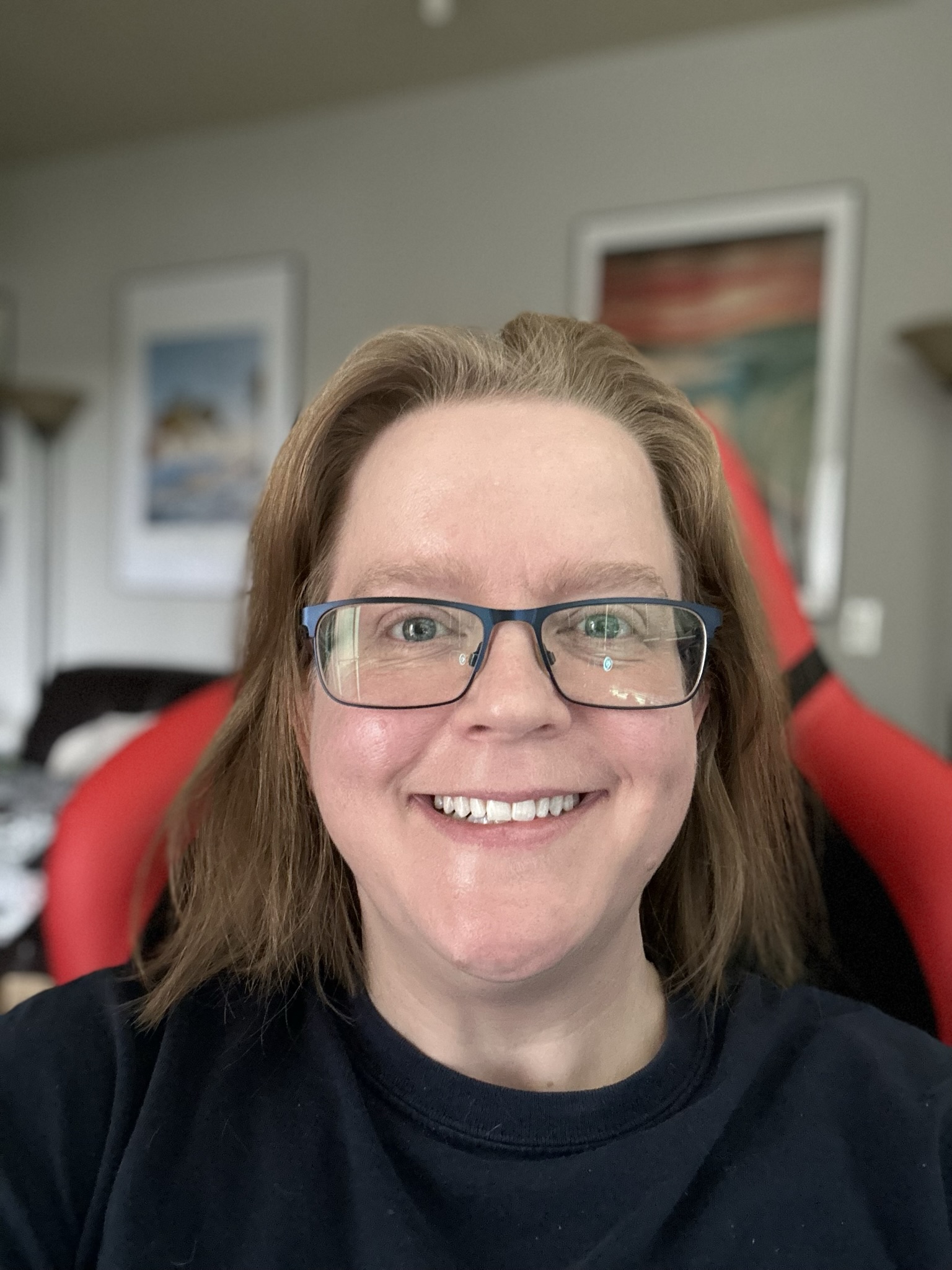 Ashley smiles in front of an office window.
