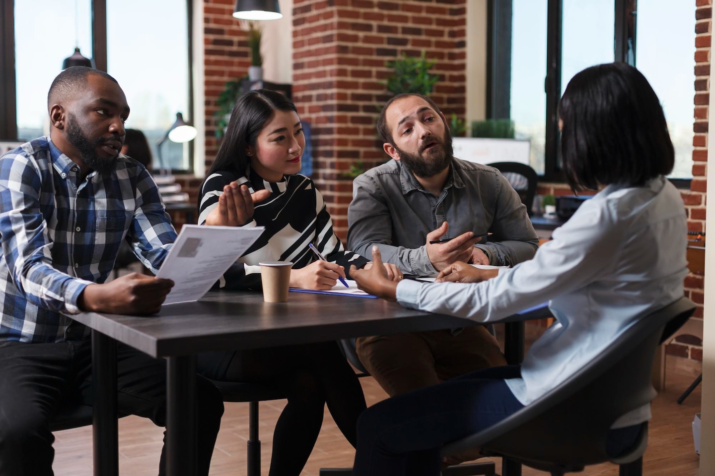 An photograph of people in an office mid-discussion