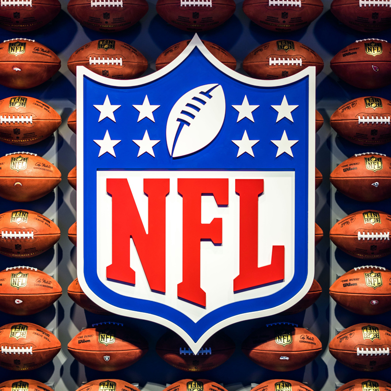 NFL Logo vor Footbällen
