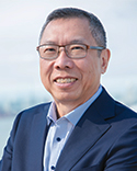 Phil smiles at the camera, wearing a navy blazer against a light background.