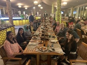 Photo of Iliyana Mladenova and her team sitting at a table while out to dinner at a restaurant.