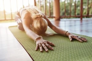 Woman doing yoga stretch on mat