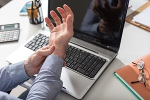 Man at desk with wrist pain