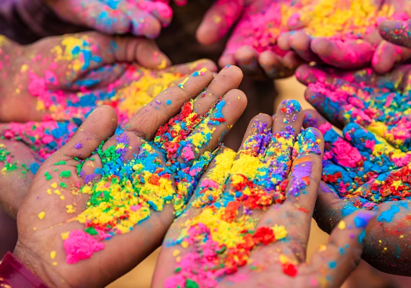 Hands in a circle with coloured powder