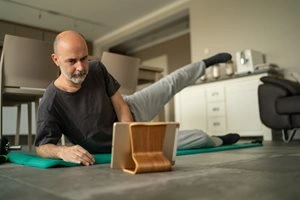 Man exercising in front of tablet