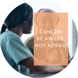 Caption reads: Cancer: Be aware not afraid. In the background, a woman wearing a head-covering due to chemotherapy speaks to a doctor.