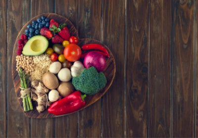 Healthy foods including fruit, vegetables, grains and legumes on a heart shaped plate.