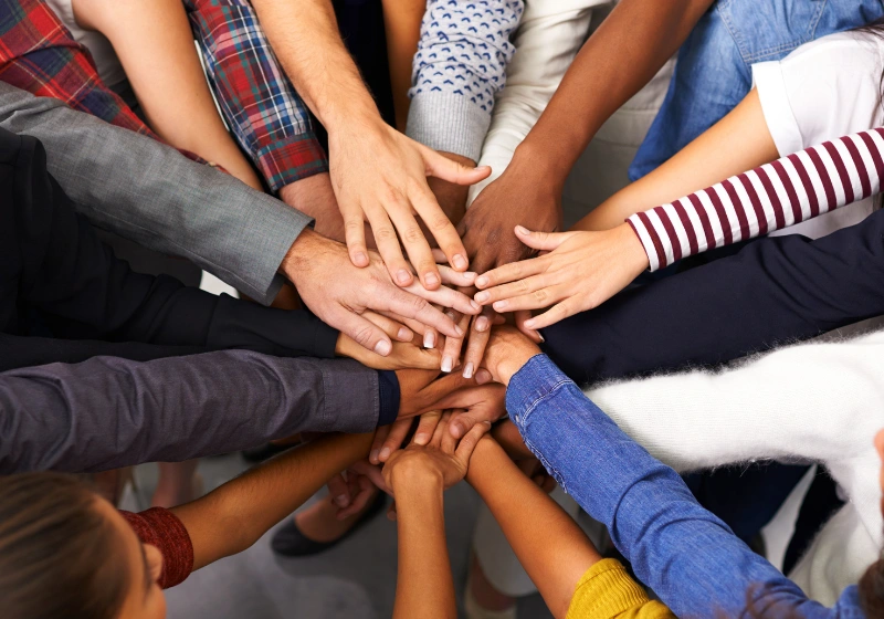 A photo of lots of hands in a circle