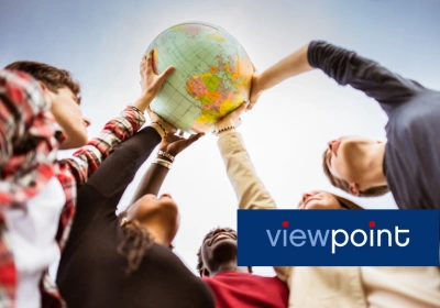 A group of people hold a globe up together