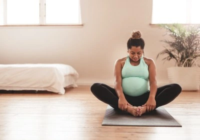 Pregnant woman doing yoga on a mat