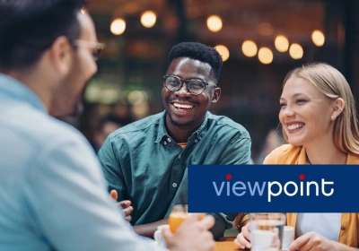 Three co-workers laugh together at a social event.