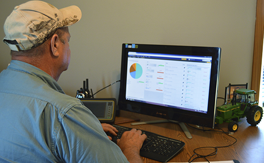 A farmer analyzes his farm data from the office using Trimble Ag Software.