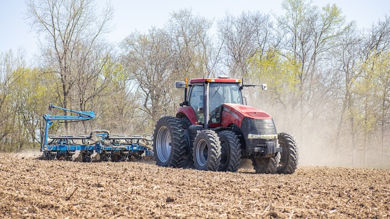 Ein Landwirt bei Pflanzarbeiten auf dem Feld mit einer Spurführung von PTx Trimble.
