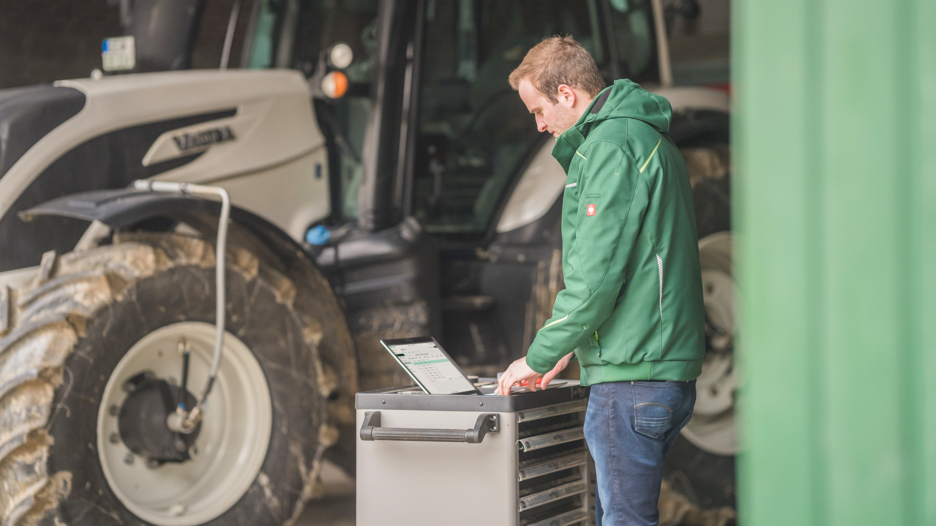 A man uses PTx FarmENGAGE on his laptop in his shop