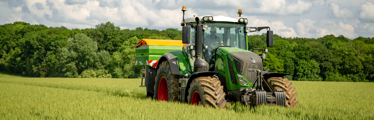 A farmer spreads fertilizer on a farm in France using Fendt equipment.