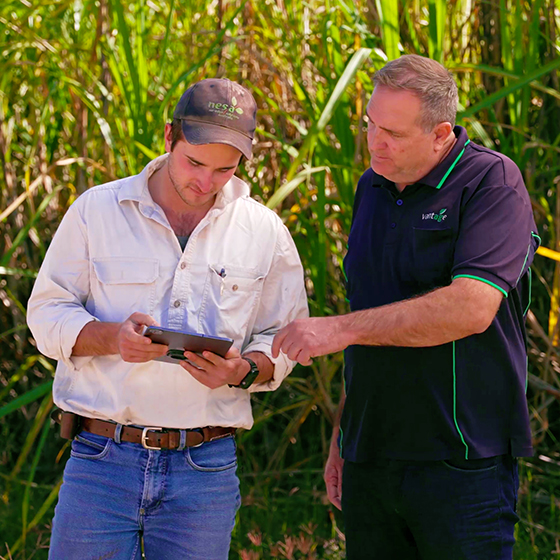 A farmer talks to his Trimble Authorized Dealer while looking at a tablet.