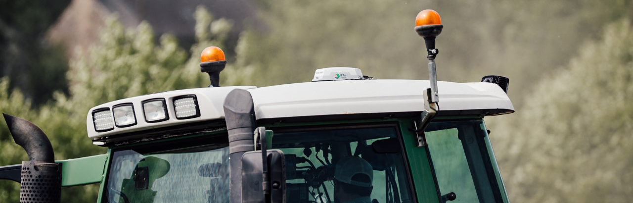 The NAV-960 receiver from PTx Trimble on the roof of a green tractor.