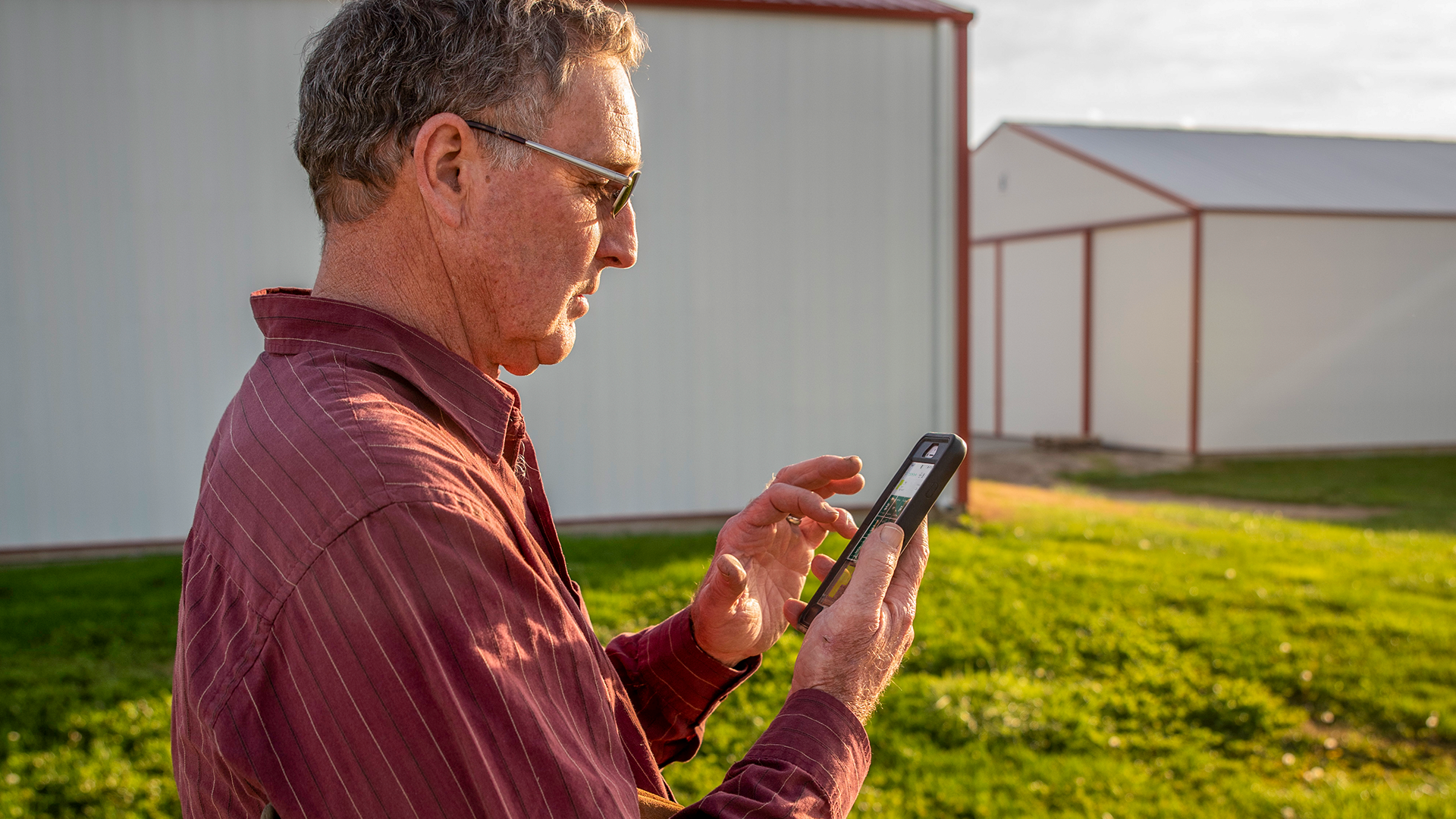 A man uses PTx FarmENGAGE on his cell phone.