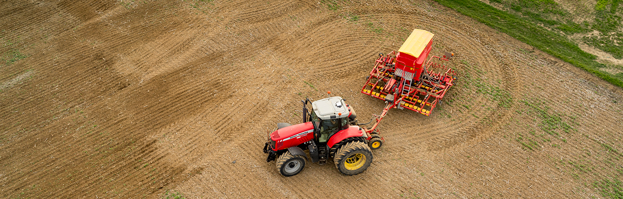 A red tractor planting in an open field