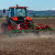 A farmer prepares their field for harvest using a Kubota tractor and Trimble guidance.