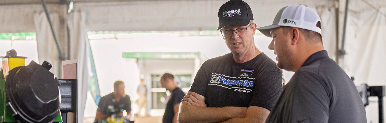 A PTx employee talks to a farmer at Farm Progress Show
