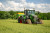 Tractor spreading fertiliser driving through a field