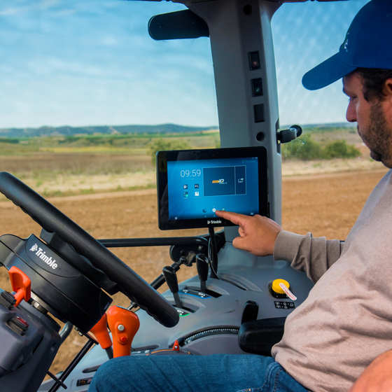 Un agricultor utiliza su pantalla GFX-750 con un sistema de dirección de Trimble para mejorar la exactitud de sus tareas agrícolas.