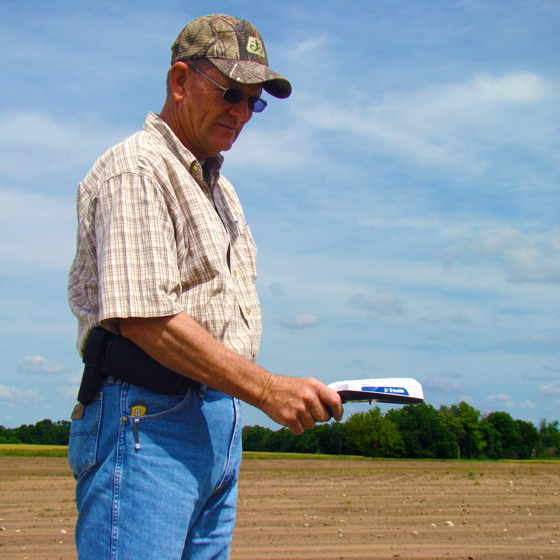 Un agricultor usa el sensor portátil de cultivos GreenSeeker de Trimble.